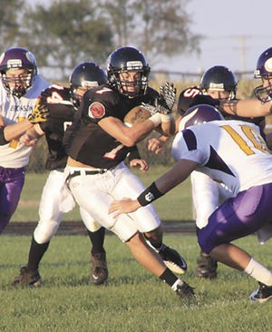 Mike Niblock protects the football before being tackled by Bronson’s Hayden Jergens (10) on Friday night.