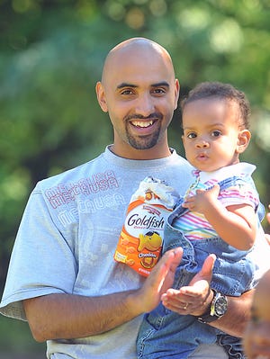 Victor Claudio holds his daughter Isabella,18 months, as they enjoy the Antioch Church Block Party at Weir Park on Saturday, Sept. 11.