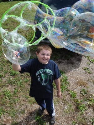 Tyler Hummer, 10, of Kresgeville, makes bubbles during the second Ross Township Community Day Fair at the VanBuskirk-Haney Park in Saylorsburg on Saturday afternoon.  To purchase a reprint of this photo, go to  www.PoconoRecord.com/photostore.