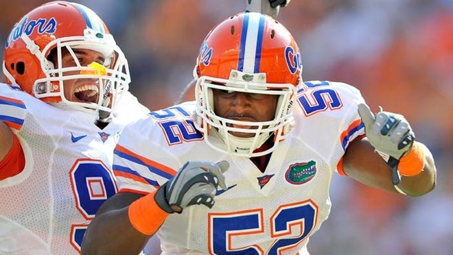 Jonathan Bostic (52), a freshman from Palm Beach Central, celebrates with teammate Justin Trattou after Bostic intercepted a pass in the end zone during the Gators' win Sept. 18, 2010.