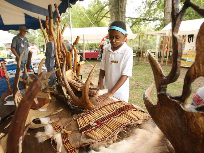 Odell Malone, 9, looks at carved moose antlers and beadwork created by Clyde Burford on display at the Moundville Native American Festival in Moundville in 2009.