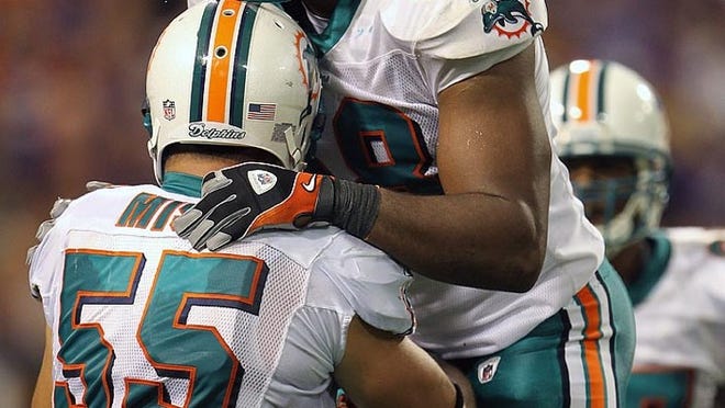Dolphins linebacker Karlos Dansby (58) celebrates with Koa Misi after the Dolphins recovered a fumble in the end zone for a touchdown during Miami's 14-10 win over Minnesota on Sept. 19, 2010.