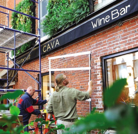 Charles Hugo, landscape architect, right, and Brian Jusczak install pieces of the vertical garden which will be permanent on the outside of Cava Tapas and Wine Bar on Commerical Alley in Portsmouth.