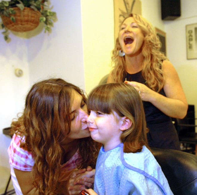 Vivian Wuschke, 4, gets a kiss from her mother, Bonnie, as Kelly Reilly looks on.