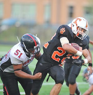 Taunton High running back Cabrinni Goncalves tries to break the tackle of a Durfee defender during Friday's game at Taunton High School.