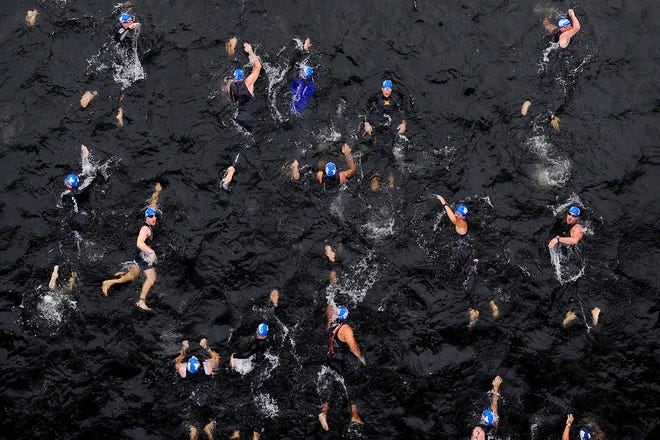 Male participants compete in the 1.2-mile swim in the Savannah River during the ESi Ironman 70.3 Augusta on Sunday. More than 3,000 people were entered in the event that involves swimming, running and cycling disciplines.