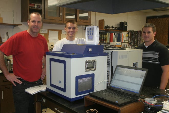 From left, assistant professor of chemistry Brad Sturgeon, lab coordinator Steve Distin and Adam Keil, senior scientist for ICx Technologies, show off the GC/MS that was installed at Monmouth College earlier in the day.