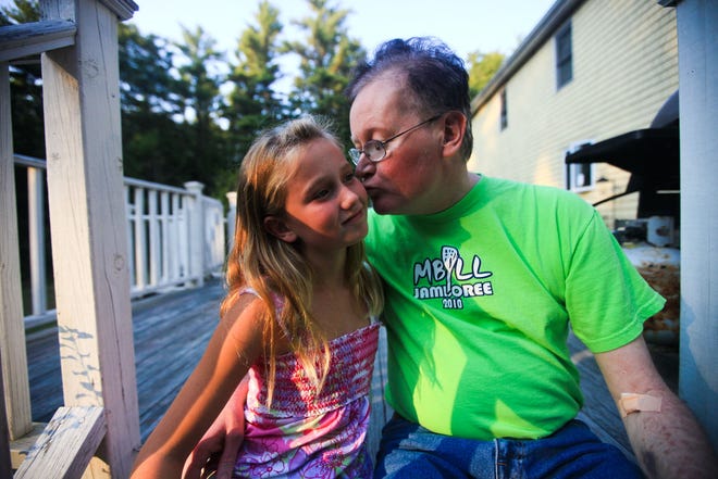 Elana Sargent gets a kiss from her father, John, at their home in Lakeville. John Sargent was diagnosed with an aggressive form of brain cancer last year.