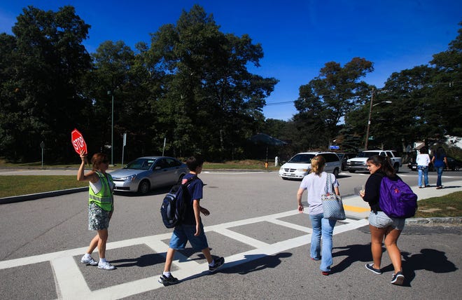 Easton Middle School crossing guard Debbie Wells assists students safely across the street.