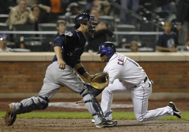 New York Mets' Luis Castillo scores the winning run in the ninth inning, sliding in ahead of the throw to Milwuakee Brewers catcher George Kottaras on Ruben Tejada's double in the Mets' 4-3 win Tuesday, Sept. 28, 2010, in New York.