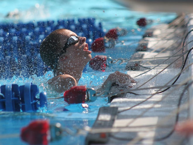 A swimmer hits the wall during the 200 free relay at the Rob Ramirez City Championship Meet at Westside Park on Saturday.