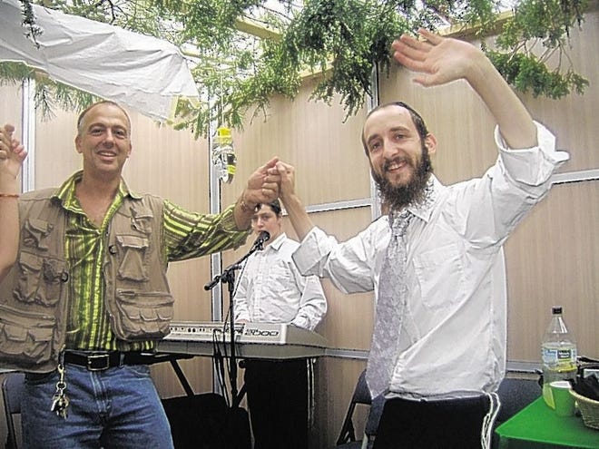Alejandro Dron of Newburgh and Rabbi Shmuel Serebryanski celebrate the fall harvest and the commemoration of the Exodus in a Sukkot party.