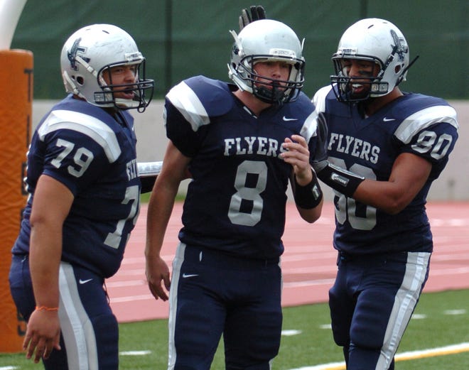 Framingham's Greg Finley (center) is congratulated by Donald Goff (right) and Ramon Torres after scoring a touchdown in the Flyers' win over Brookline.