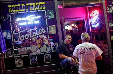 Patrick Hartman carries a gun while checking IDs at Tootsies, a Nashville bar where customers are allowed to take weapons if they have a permit.