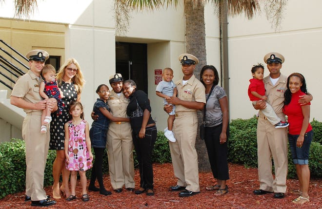 Selectees and their families line up for a picture immediately following the ceremony. Pictured from left Chief Engineman Jason Mozer, Fiona Mozer, Stacie Mozer, Amelia Mozer, Carina George, Chief Culinary Specialist Cordelia Vernon, Catrina George, Kenneth Horne Jr., Chief Intelligence Specialist Kenneth Horne, Lynette Horne, Jaedon Ali, Chief Damage Controlman Shimran Ali, and Cherisa Ali.