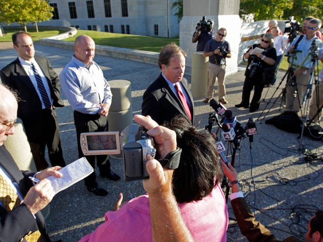 Country Crossing gaming facility owner Ronnie Gilley, third from left, listens as his attorney Doug Jones, at podium, talks with reporters outside the Federal Courthouse in Montgomery on Monday. Gilley and 10 others were indicted on federal conspiracy and bribery charges over buying votes for a bingo bill in the Alabama Senate.