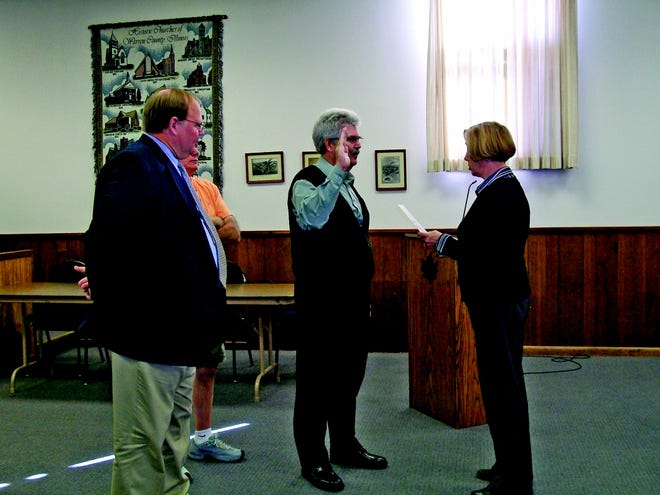 City Clerk Susan Trevor and Mayor Rod Davies swear in new Monmouth Fire Chief John Cratty Friday at City Hall. Cratty served as the Galesburg Fire Chief for 15 years before retiring in August 2009.