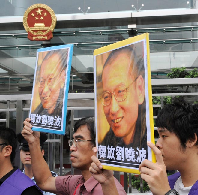 Pro-democracy protesters hold the picture of Chinese dissident Liu Xiaobo with Chinese words "Release Liu Xiaobo" during a demonstration outside the China Liaison Office in Hong Kong Friday, Oct. 8, 2010. Imprisoned Chinese dissident Liu Xiaobo won the 2010 Nobel Peace Prize on Friday for using non-violence to demand fundamental human rights in his homeland.