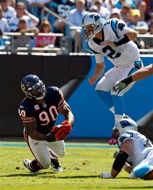 Chicago Bears' Julius Peppers (90) catches a tipped pass from Carolina Panthers' Jimmy Clausen (2) for an interception in the first half of an NFL football game in Charlotte, N.C., Sunday, Oct. 10, 2010. (AP Photo/Chuck Burton)