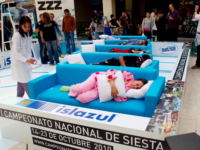 A doctor checks as people sleep a siesta during the first Siesta Championship in Madrid, Thursday, Oct. 14, 2010. The participants of the siesta contest win points for the first person to fall asleep, the loudest snorer, best original sleeping position and best dressed sleeper. Doctors are present to check if the contestants are really asleep. (AP Photo/Paul White)