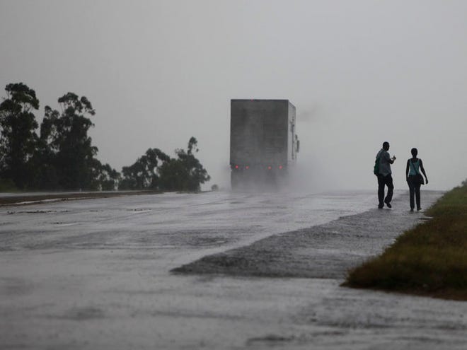 A couple walks along a highway as Hurricane Paula approaches the island in San Cristobal, Cuba, Wednesday, Oct. 13, 2010.(AP Photo/Javier Galeano)
