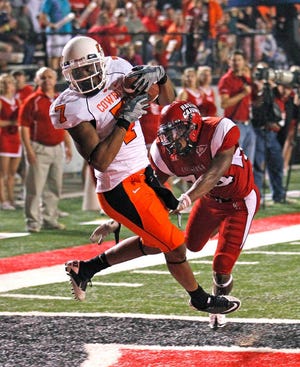 Oklahoma State wide receiver Michael Harrison (7) pulls in a touchdown pass in front of Louisiana-Lafayette safety Lionel Stokes (24) during the second half of an NCAA football game in Lafayette, La., Friday, Oct. 8, 2010. (AP Photo/Gerald Herbert)