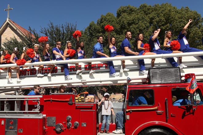 The University of Florida cheerleaders ride a fire truck at the Homecoming Parade.