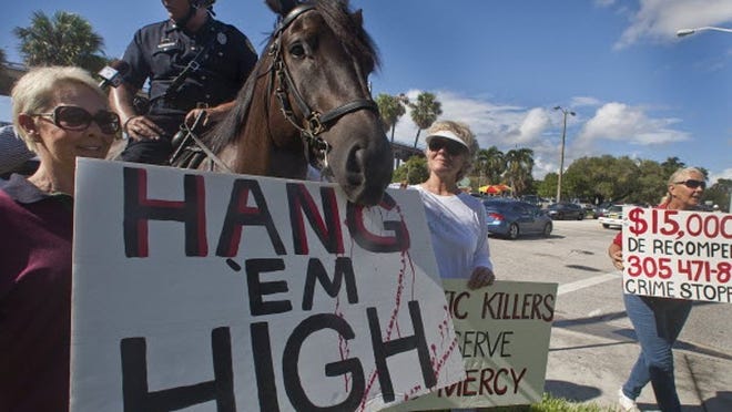 City of Maimi's police officer Dave Patton's horse Apollo, temporarily holds on to a protest sign from Gail McOwen during a protest deriding the slaughter of horses in South Florida where two men arrested for stealing/slaughtering horses will appear at another pre-trial hearing before Judge Sara Zabel. The protest took place on September 7, 2010, in front of the Richard Gerstein Justice Building in Miami. Officer Patton and another mounted policmen were on hand to maintain order; they were not part of the protest.