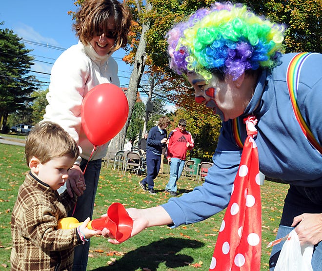 Liam Wolfe, 2, of Framingham, interacts with a clown while his mother, Katie Boch, looks on at the 20th annual Pies on the Common Fair on Saturday afternoon.