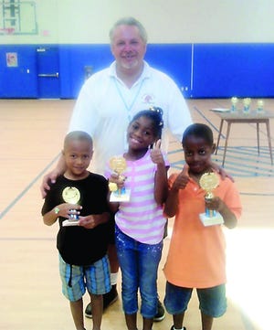 Dean DeKnight of the Elks Lodge stands with Jabari Carpenter, Hataja Gordon and Zahki James the 6 and 7-year-old first through third place winners.