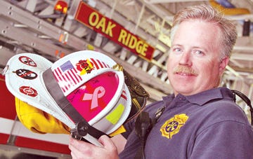 Oak Ridge Fire Department Battalion Chief David Harrington shows the breast cancer sticker on his helmet.