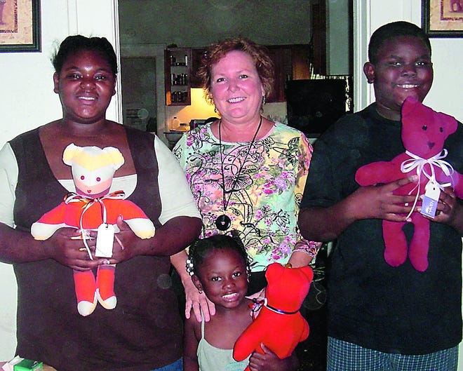 Haven Volunteer Beth Love presents three "memory bears" to a family served by Haven Hospice. Pictured from left: T.C. Bell, Love, C.J. Mangum, Jr. and Lamyracle Townsend.