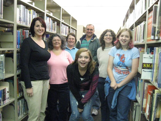 The Book-Keepers Club meets at 6 p.m. every third Tuesday of each month at the Chatham Area Public Library. Pictured from left to right in their favorite section - science fiction -are Katie Mergen, Debi Rose, Carol Dankoski and her husband, Dave, Rebecca McGuire and her daughter, Rachel, and Jo Oakman (center front).