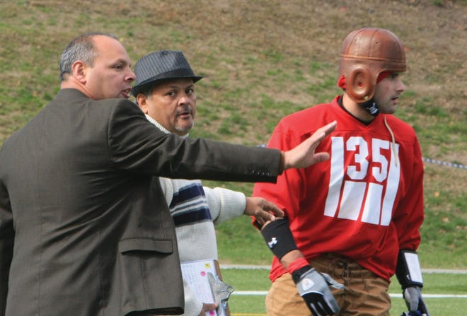 (Top right) Mickey Meza, (far left) instructs #35 Ryan Logan while FHS Head Coach, Marcos Meza looks on.