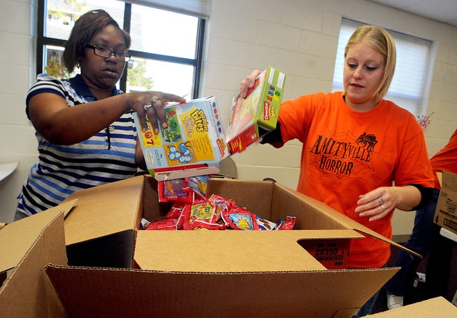 Carrie Lott (left) and Ashley Thompson (right) sort candy into boxes on Thursday for the King Community Campus' Fall Costume Ball next Wednesday.