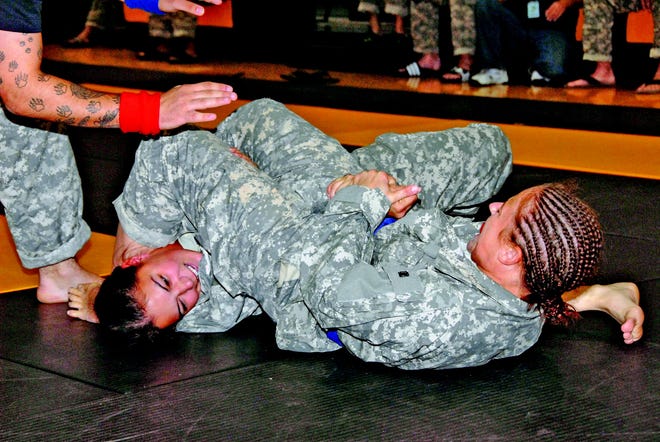 Spc. Beth Revell (right) of Granite City places an arm bar submission on her opponent during the first round at the All-Army Combatives Tournament.