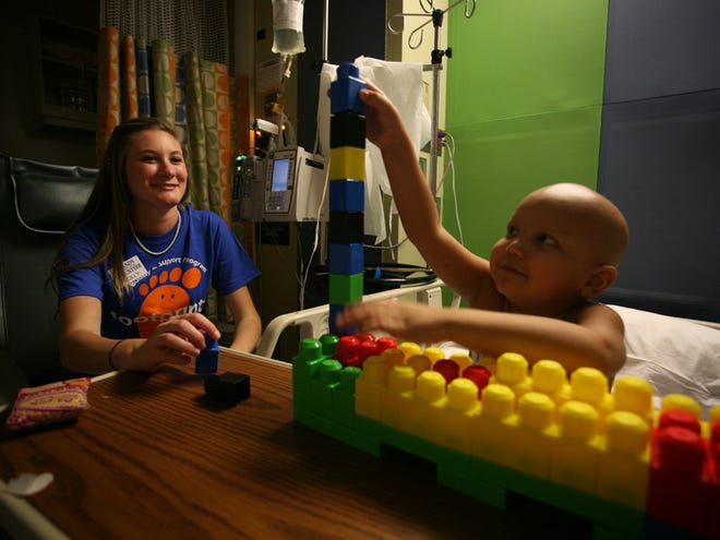 Darian Baker, 4, builds a tower of blocks with his Footprints buddy, Molly Williams, in the new cancer unit at Shands Hospital on Wednesday. Footprints is a program that matches young cancer patients and their families with mentors. The buddies play with the children and help the family with basic needs.
