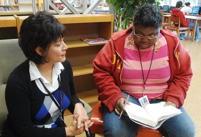 Liz Brown, literacy first coach at Freeport High School, talks to senior Monica Walker in the school's library Thursday. Bowen has received the "Those Who Excel" award.