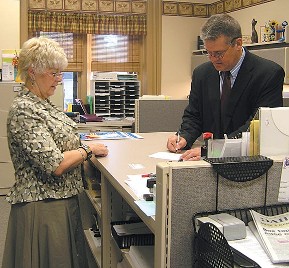 P. J. Johnson of the Livingston County Clerk’s office stands by as Senator Dan Rutherford, R-Chenoa, registers for early voting at the Livingston County Courthouse on Monday. Rutherford is on the ballot seeking a term as state treasurer.