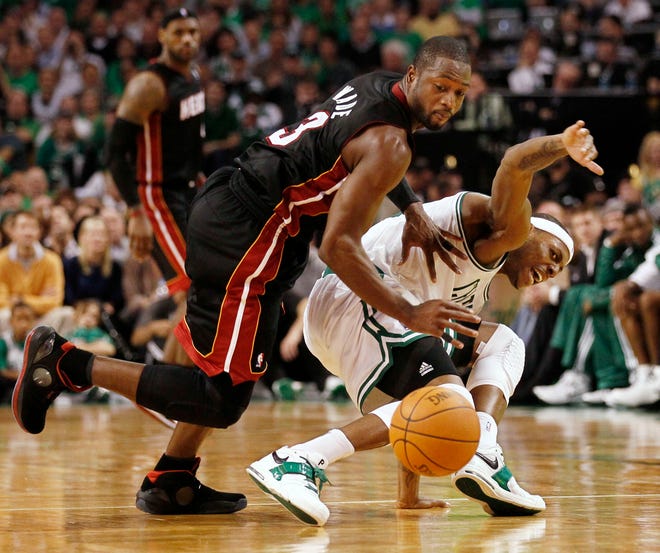 Miami Heat guard Dwyane Wade, left, shoves Boston Celtics forward Paul Pierce away from the ball during the second quarter of an NBA basketball game in Boston on Tuesday, Oct. 26, 2010.