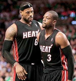 Miami Heat's LeBron James, left, talks with teammate Dwyane Wade during the second quarter of Tuesday's against the Boston Celtics in Boston. By WINSLOW TOWNSON, The Associated Press