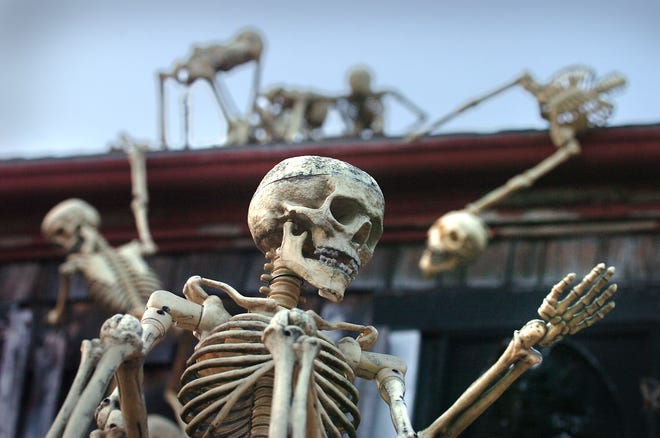 Skeletons adorn the roof of Barrett's Haunted Mansion.