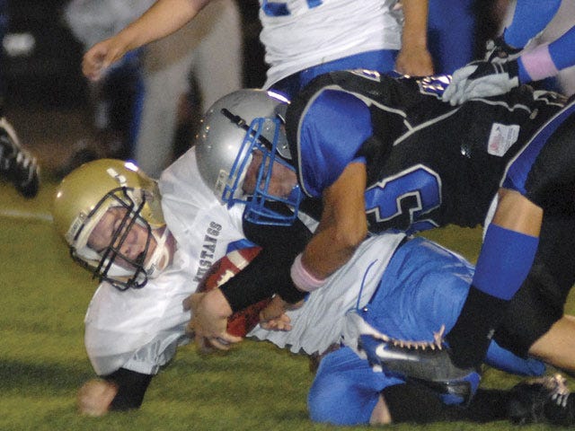 Silver Valley's Carmelo Garret tackles Lucerne Valley's Kevin Sheldon for a loss Friday night at Don Price Field.