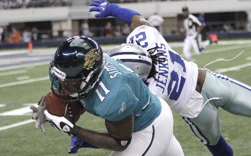 Jacksonville Jaguars wide receiver Mike Sims-Walker (11) pulls in a pass against Dallas Cowboys cornerback Mike Jenkins (21) during the second quarter in Arlington, Texas, Sunday.