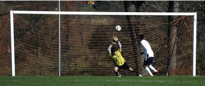 Photo by Daniel Freel/New Jersey Herald 
Sparta’s Chris McGurrin, right, shoots the ball over West Milford’s goalkeeper Greg Mascola during the Spartans’ first-round game of the North 1, Group 3 state sectional tournament in Sparta Monday. Sparta won, 2-1.