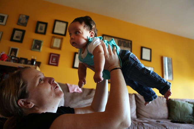 Kat Ryan plays with her daughter, Zoe Ryan-Riley, 2 months, at their home in Chicago. Kat Ryan was recently hospitalized for exhaustion. Prolonged periods of physical stress and sleep deprivation can cause problems that shouldn't be ignored, experts say.