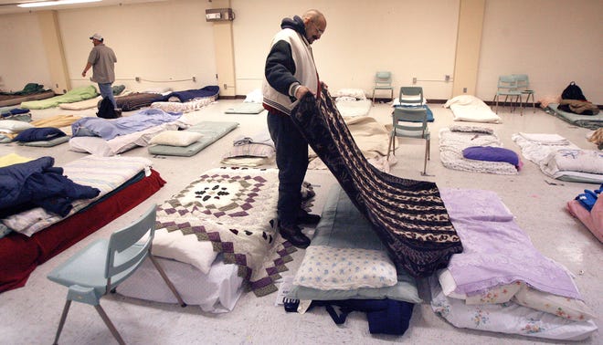 Because of the brutal cold weather on Tuesday January 5, 2010, the overflow shelter for members of Springfield's homeless population opened about 45 minutes early. The shelter is located in the former First United Methodist Church building at 5th and Capitol ave. In the basement of the former church, Mark Jasmon readies his bed with a blanket Tuesday.
