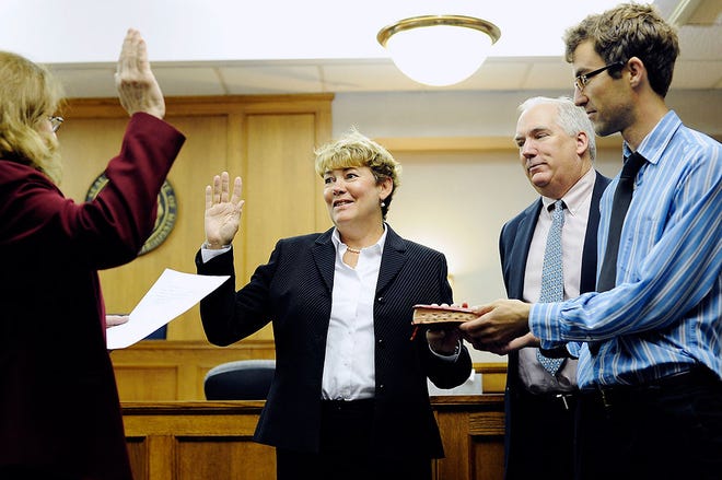 Circuit Judge Jodie Asel, left, swears in newly appointed Circuit Judge Christine Carpenter, center, as Carpenter’s husband, Joe Bindbeutel, second from right, and son Burke Bindbeutel hold a Bible Friday at the Boone County Courthouse. Carpenter replaces Judge Gene Hamilton, who retired earlier this year.