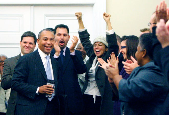 Gov. Deval Patrick, left, is greeted by staff members yesterday at the State House in Boston as he returns after being re-elected in Tuesday's election.