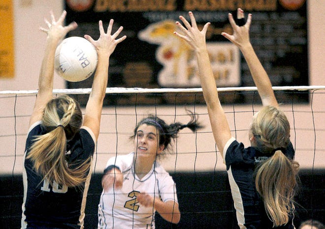 Buchholz's Gaby Rubeis (2) spikes the ball between two Tallahassee Lincoln defenders during their game on Nov. 3, 2010 at Buchholz High School. The Bobcats won in three games.